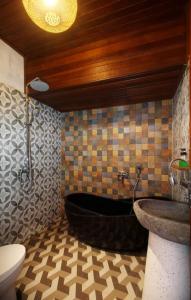 a bathroom with a bath tub and a sink at Tri Datu Palace in Saba