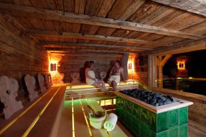 two people sitting in a wooden room with a table at Tanne Tonbach - Wellness & Wohlfühl Hotel in Baiersbronn