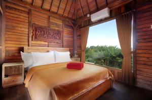 a bedroom with a large bed with a large window at Tri Datu Palace in Saba