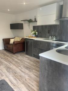 a kitchen with a sink and a couch in a room at The Little Red lion in Thorpe