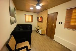 a living room with a black couch and a wooden door at Cabaña Polo in Concepción de La Vega +14 photos