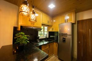 a kitchen with wooden cabinets and a stainless steel refrigerator at Cabaña Polo in Concepción de La Vega