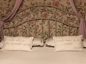 a bed with two pillows and a floral wall at Aria di Campagna in Lodi