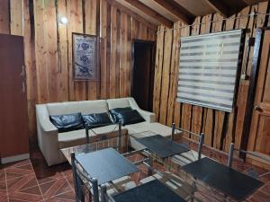 a living room with a couch and a table and chairs at cabaña vale in Coñaripe