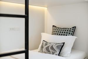 a room with a bed with two pillows and a mirror at CASA BLANCA Dusit in Dusit