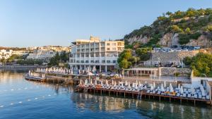 a pier with chairs and a hotel on the water at La Quinta by Wyndham Bodrum in Bodrum City