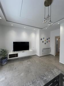 a living room with a flat screen tv on a white wall at Jasmine Apartment Tunis in Tunis