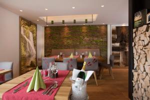 a dining room with a table with a bottle of wine at Tanne Tonbach - Wellness & Wohlfühl Hotel in Baiersbronn