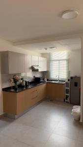 a large kitchen with white cabinets and black counter tops at Al Azaiba apartment in Muscat