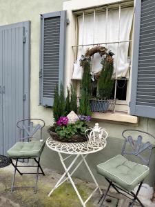 a table and two chairs and a window with flowers at Aria di Campagna in Lodi