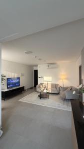 a living room with a couch and a tv at Al Azaiba apartment in Muscat