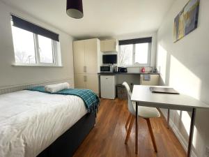 a bedroom with a desk and a bed and a table at The Studios, Dedworth Road, by Accommodation Windsor in Windsor +8 photos