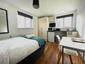 a bedroom with a bed and a table and a kitchen at The Studios, Dedworth Road, by Accommodation Windsor in Windsor