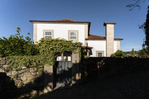 a house with a stone fence in front of it at Casas da Memória in Tarouca