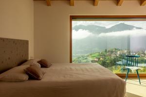 a bedroom with a bed and a large window at Maso al Sole Agriturismo in Civezzano +45 photos