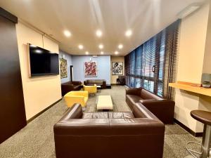a living room with a leather couch and a tv at Executive Hotel in Forlì
