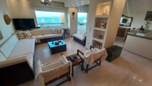 a living room with white furniture and a large window at Villa Veranda in Neoi Epivates