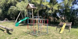 a park with a playground with a slide and a swing at Chacra Los Arándanos in Durazno +9 photos