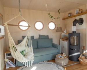 a hammock in a living room with a blue couch at Wohnwagon BALU in Apetlon