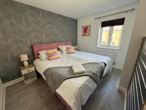 a bedroom with a large bed and a window at Chislehurst House in Bedford