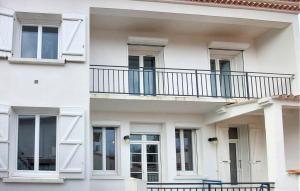 a white building with a balcony on it at Charmante Maison Proche Mer in Royan