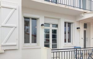 a white house with windows and a balcony at Charmante Maison Proche Mer in Royan +22 photos