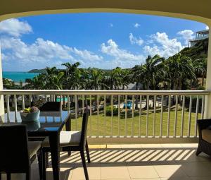 a balcony with a table and a view of the ocean at Breathtaking Views Private 1 Bed Villa in Freetown Village