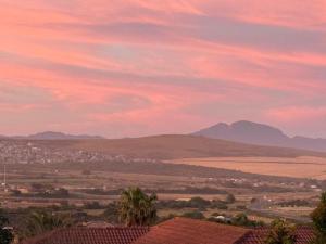 a view of a city at sunset with mountains at Hettie's Cottage in Hartenbos +3 photos