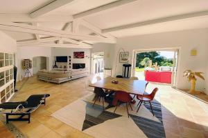 a living room with a table and chairs and a couch at Luxury Villa, Infinity Pool, Beach 5 min in Ramatuelle