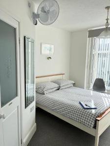 a bedroom with a bed with a fan and a window at Westward B&B in Newquay
