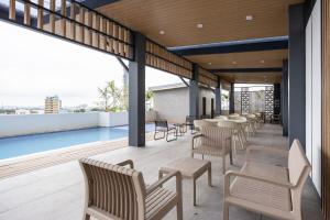 a balcony with tables and chairs and a pool at Layla by J&J At J Towers Residences It's just right next to SM JMall in Mandaue City