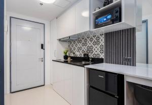 a kitchen with white cabinets and a white door at Layla by J&J At J Towers Residences It's just right next to SM JMall in Mandaue City