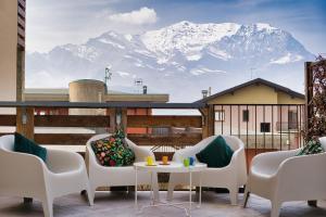 a balcony with a table and chairs and a mountain at NNHouse: large terrace and marvelous view in Cassina Valsassina