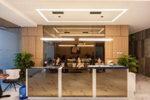 a group of people sitting at a table in a lobby at Layla by J&J At J Towers Residences It's just right next to SM JMall in Mandaue City +24 photos