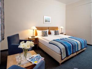 a hotel room with a bed and a chair and a table at Hotel Gutenberg in Westerland