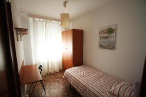 mała sypialnia z łóżkiem i oknem w obiekcie Malaga Soho w Maladze