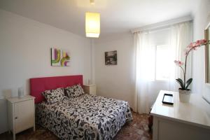 mała sypialnia z łóżkiem i oknem w obiekcie Malaga Soho w Maladze