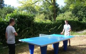 two people standing around a ping pong table at ZEcamping 3 pataugeoire animations locatif TV BBQ 24m2 4 pers in La Souterraine