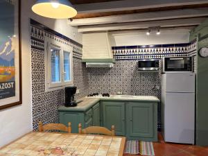 a kitchen with green cabinets and a white refrigerator at Appartement 4 personnes - Laruns in Laruns +4 photos