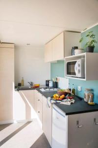 a kitchen with white cabinets and a black counter top at Camping 3 étoiles - Piscine - ccbfgbf in Collias