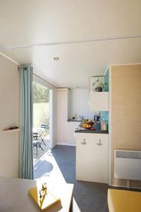 a room with a kitchen with a table and a counter at Camping 3 étoiles - Piscine - ccbfgbf in Collias +26 photos