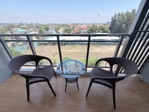 three chairs and a glass table on a balcony at Whale Marina Condo in Na Jomtien