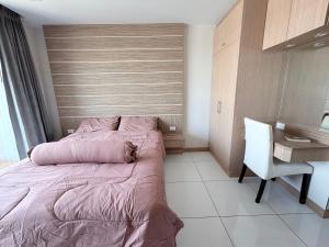 a bedroom with a bed and a desk and a chair at Whale Marina Condo in Na Jomtien