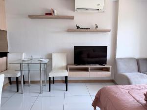 a living room with a table and a television at Whale Marina Condo in Na Jomtien