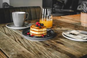 a table with a plate of cake and a cup of orange juice at Fliegerdeich Hotel & Restaurant in Wilhelmshaven