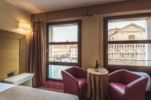pokój hotelowy z łóżkiem, dwoma krzesłami i oknem w obiekcie THE DOME - Panoramic Rooms w mieście Ferrara +86 zdjęć