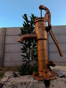 an old rusty fire hydrant sitting on a rock at La Micha in Chascomús