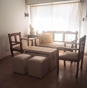 a living room with a couch and a chair and a window at La Micha in Chascomús