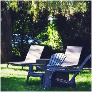 two lawn chairs sitting in the grass in a park at Hotel Les Terrasses in Annecy