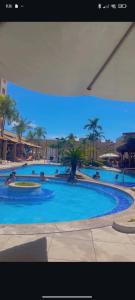 a large blue swimming pool with people in it at Boulevard suite hotel apartamento 434 in Caldas Novas +2 photos